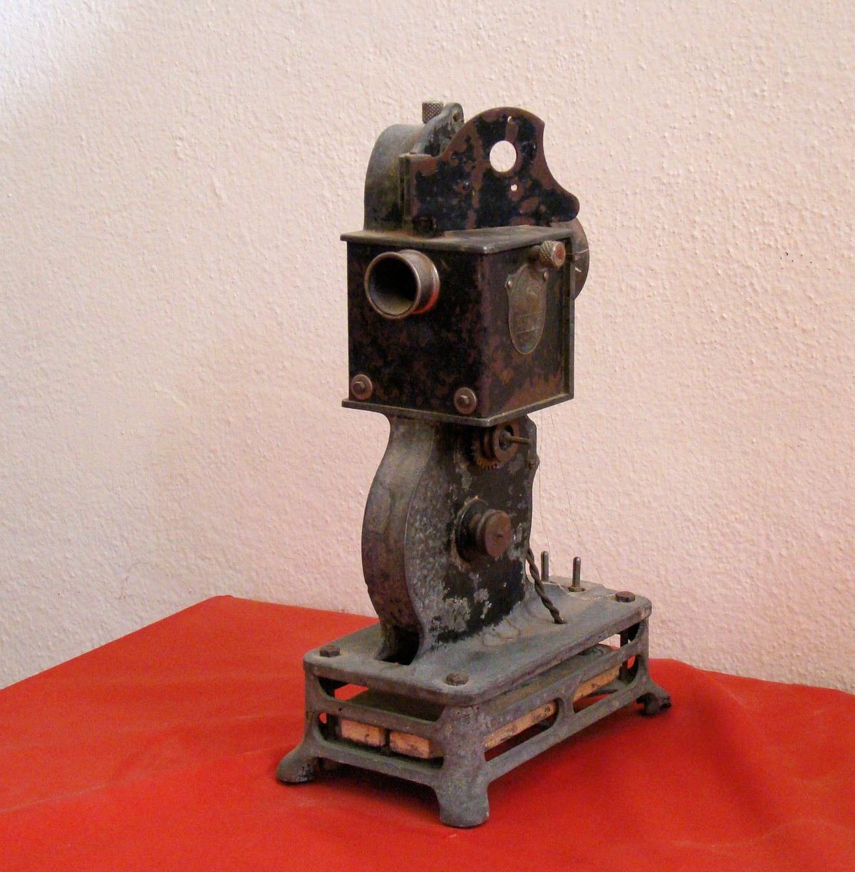 Antique Pathé-Baby film projector displayed on a red cloth in the Ouarzazate cinema museum