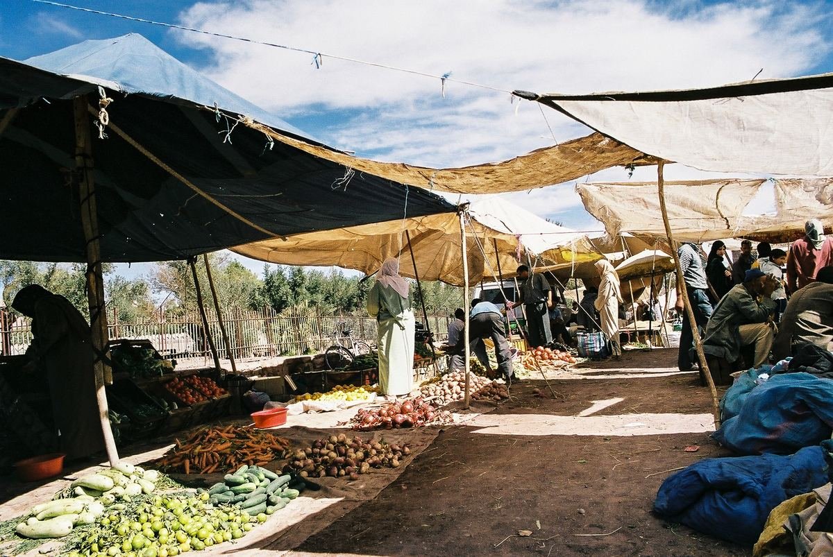 Étals de légumes sous des bâches sur un marché de rue à Ouarzazate