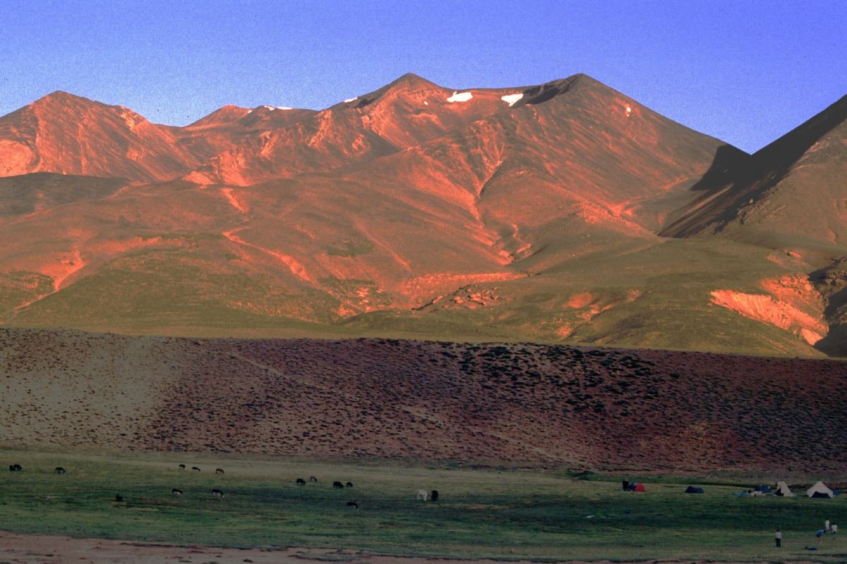 La crête de l'Ighil M'Goun rougie par le lever du soleil au-dessus d'une vallée verte