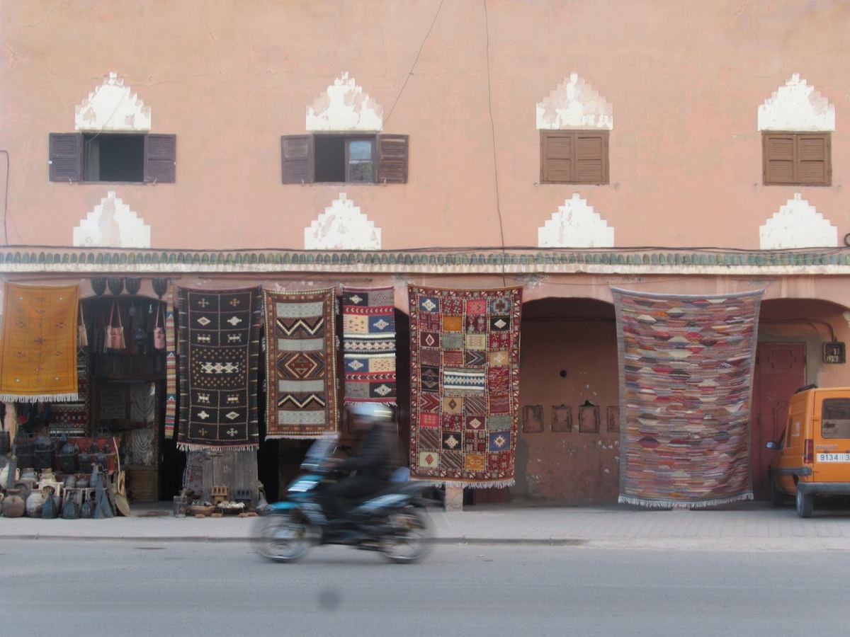 Tapis berbères suspendus sur la façade d'une boutique dans une rue de Ouarzazate