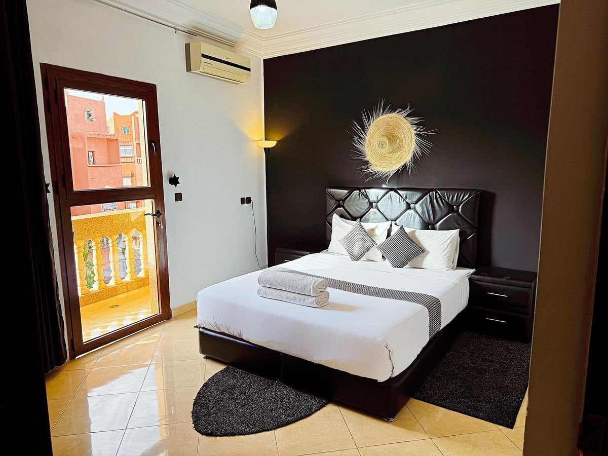 King-size bedroom with sunburst mirror and balcony access